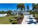 Beautiful home with a well-manicured lawn, palm trees, and a paved driveway at 2466 Breakwater Cir, Sarasota, FL 34231