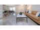 Bright living room featuring a tan leather sofa, accent chair, tiled floors and shelving at 2466 Breakwater Cir, Sarasota, FL 34231