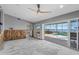 Spacious living room with ceiling fan and sliding glass doors to a waterfront pool at 2604 Palma Sola Blvd, Bradenton, FL 34209