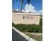 Welcoming entrance to Pinewood Village featuring lush landscaping and clear signage, creating an inviting first impression at 2763 Woodgate Ln # 208, Sarasota, FL 34231