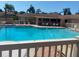A serene view of the community pool with lounge chairs, tables, and well-maintained fencing at 2763 Woodgate Ln # 208, Sarasota, FL 34231