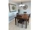 Dining room featuring a modern chandelier, a wooden table with seating for four, and neutral walls at 2763 Woodgate Ln # 208, Sarasota, FL 34231
