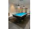 This game room features a blue felt pool table and plenty of cues at 2763 Woodgate Ln # 208, Sarasota, FL 34231