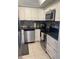 Modern kitchen featuring stainless steel appliances, granite countertops, and white cabinetry at 2763 Woodgate Ln # 208, Sarasota, FL 34231