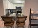 Modern kitchen view with stainless steel appliances, white cabinets, and a breakfast bar at 2763 Woodgate Ln # 208, Sarasota, FL 34231