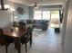 Bright living room and dining area with tiled floors, ceiling fan, and sliding glass doors to the balcony at 2763 Woodgate Ln # 208, Sarasota, FL 34231