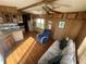 Cozy living room featuring wood paneling, a ceiling fan, and comfortable seating arrangement, ideal for relaxation at 3333 26Th E Ave # 1025, Bradenton, FL 34208