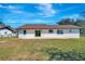 A spacious backyard features a sliding glass door entrance and a concrete patio at 3389 Dunbar St, Port Charlotte, FL 33948