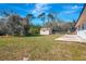 View of the oversized backyard with a storage shed, concrete slab and mature trees at 3389 Dunbar St, Port Charlotte, FL 33948