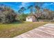 View of the large backyard with an storage shed, concrete slab and mature trees at 3389 Dunbar St, Port Charlotte, FL 33948