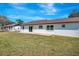 View of the spacious backyard, the rear of the home, and a concrete patio at 3389 Dunbar St, Port Charlotte, FL 33948