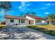 Exterior front view of the charming home with an arched portico, mature landscaping, and a driveway at 3389 Dunbar St, Port Charlotte, FL 33948