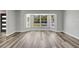 Bright living room with natural light, light gray walls, and attractive gray laminate wood flooring at 3389 Dunbar St, Port Charlotte, FL 33948
