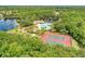 Stunning aerial view of community amenities featuring pool, tennis courts, playground, and lake access at 368 Snapdragon Loop, Bradenton, FL 34212