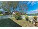 Beautiful backyard featuring a white picket fence, lush greenery, and a view of the lake at 368 Snapdragon Loop, Bradenton, FL 34212