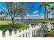 Scenic backyard view with white picket fence overlooking a serene lake at 368 Snapdragon Loop, Bradenton, FL 34212