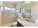 Bathroom featuring a tiled shower, a large mirror, and a granite-topped vanity at 368 Snapdragon Loop, Bradenton, FL 34212