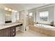 Bright bathroom with a tiled shower, a separate soaking tub, and a granite-topped vanity at 368 Snapdragon Loop, Bradenton, FL 34212