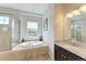 Bright bathroom with a large soaking tub, a walk-in shower, and a granite-topped vanity at 368 Snapdragon Loop, Bradenton, FL 34212