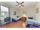 Cozy bedroom featuring hardwood floors, a ceiling fan, and two twin beds with blue and white bedding at 368 Snapdragon Loop, Bradenton, FL 34212