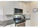 Modern kitchen with stainless steel appliances, granite countertops, and gray tile backsplash at 368 Snapdragon Loop, Bradenton, FL 34212