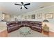 Open-concept living room with leather sectional and glass coffee table next to the kitchen at 368 Snapdragon Loop, Bradenton, FL 34212