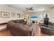 Spacious living room featuring a comfortable leather sectional and a view of the screened pool and patio at 368 Snapdragon Loop, Bradenton, FL 34212