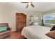 Comfortable bedroom with wood flooring, ceiling fan, and view of the pool and lake at 368 Snapdragon Loop, Bradenton, FL 34212