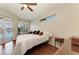 Bright main bedroom with wood floors, a ceiling fan, and views of the pool area through large windows at 368 Snapdragon Loop, Bradenton, FL 34212
