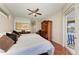 Spacious main bedroom featuring a ceiling fan, a large armoire, and a private balcony with a water view at 368 Snapdragon Loop, Bradenton, FL 34212