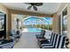 Relaxing screened patio with comfortable striped seating overlooking a beautiful pool and lake view at 368 Snapdragon Loop, Bradenton, FL 34212