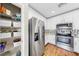 Kitchen area with stainless steel appliances, white cabinetry, and a pantry with wire shelving at 3708 Wayfarer Way, Palmetto, FL 34221