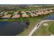 Aerial view of home near golf course and pond, surrounded by lush landscaping and a tile roof at 379 Fairway Isles Ln, Bradenton, FL 34212