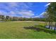 Expansive backyard with a lush green lawn and a view of the nearby golf course at 379 Fairway Isles Ln, Bradenton, FL 34212