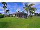 Beautiful home exterior with a screened-in patio, lush lawn, and picturesque landscaping at 379 Fairway Isles Ln, Bradenton, FL 34212