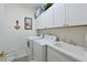 Functional laundry room equipped with washer, dryer, utility sink and ample cabinet storage at 379 Fairway Isles Ln, Bradenton, FL 34212