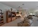 Relaxing living area with ceiling fan, entertainment center, comfortable seating, and bright view through sliding glass door at 379 Fairway Isles Ln, Bradenton, FL 34212