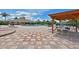 Community pool deck with decorative tile, lounging chairs, cabana and splash pad in background at 379 Fairway Isles Ln, Bradenton, FL 34212