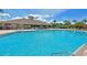 Community pool with clubhouse and palm trees on a bright, sunny day at 379 Fairway Isles Ln, Bradenton, FL 34212