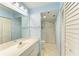 Bright bathroom with a spacious vanity, large mirror, and a walk-in shower featuring sliding glass doors at 3980 Ironwood Cir # 206, Bradenton, FL 34209