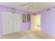 Purple bedroom with a ceiling fan, a closet, and natural light creating a relaxing atmosphere at 3980 Ironwood Cir # 206, Bradenton, FL 34209