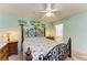 Comfortable bedroom with palm tree wall accents, a ceiling fan, and access to an en-suite bathroom at 3980 Ironwood Cir # 206, Bradenton, FL 34209
