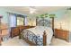 Cozy bedroom with a decorative wrought iron bed frame, two dressers, ceiling fan, and tropical wall art at 3980 Ironwood Cir # 206, Bradenton, FL 34209
