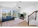 Bright living room with a large window, ceiling fan, sliding glass doors to the patio and staircase at 4091 Via Sienna Cir, Sarasota, FL 34243