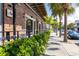 Charming brick building exterior with outdoor dining, lush greenery, and sidewalk on a sunny day at 435 S Gulfstream Ave # 1103, Sarasota, FL 34236