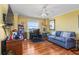 Comfortable living room with hardwood floors, desk, blue sofa, and bright sunny windows at 435 S Gulfstream Ave # 1103, Sarasota, FL 34236
