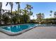 Community pool surrounded by lush tropical landscaping and brick pavers at 435 S Gulfstream Ave # 1103, Sarasota, FL 34236