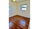 A cozy bedroom featuring hardwood floors and natural light from two windows at 4511 Ardale St, Sarasota, FL 34232