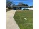 Inviting blue home with a long driveway and lush green lawn at 4511 Ardale St, Sarasota, FL 34232