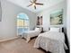 Bright bedroom with twin beds, ceiling fan, and a large window provides comfortable living at 5242 Highbury Cir, Sarasota, FL 34238